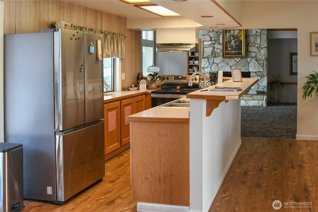 2610 E Section St Unit 20, Mount Vernon, WA 98274 - kitchen featuring stainless steel appliances, a peninsula, light wood finished floors, a breakfast bar area, and under cabinet range hood