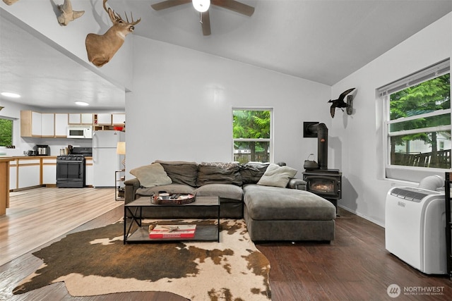 6258 Bellwood Dr, Maple Falls, WA 98266 - living area with healthy amount of natural light, a wood stove, ceiling fan, dark wood-style flooring, and lofted ceiling