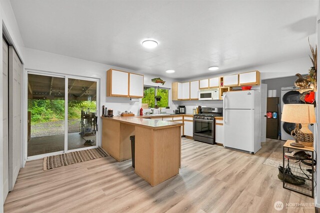6258 Bellwood Dr, Maple Falls, WA 98266 - kitchen with white appliances, a peninsula, light wood-style flooring, light countertops, and white cabinetry