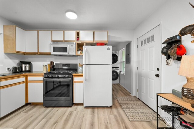 6258 Bellwood Dr, Maple Falls, WA 98266 - kitchen featuring white appliances, stacked washer / drying machine, light wood finished floors, and white cabinetry