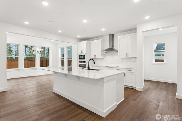 13937 181st St E Unit 8, Puyallup, WA 98374 - kitchen with wall chimney range hood, built in microwave, white cabinetry, black electric stovetop, and wood finished floors