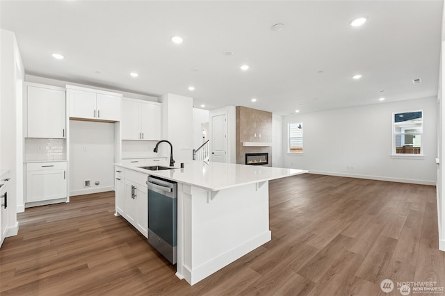 13937 181st St E Unit 8, Puyallup, WA 98374 - kitchen featuring stainless steel dishwasher, backsplash, white cabinets, an island with sink, and open floor plan