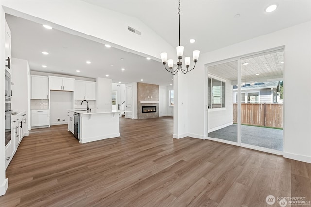 13937 181st St E Unit 8, Puyallup, WA 98374 - kitchen with open floor plan, wood finished floors, white cabinets, a chandelier, and light countertops
