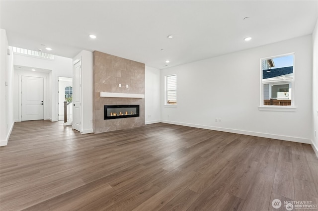 13937 181st St E Unit 8, Puyallup, WA 98374 - unfurnished living room with wood finished floors, plenty of natural light, a tiled fireplace, and recessed lighting