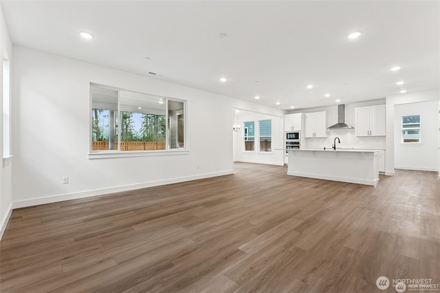 13937 181st St E Unit 8, Puyallup, WA 98374 - unfurnished living room with healthy amount of natural light, wood finished floors, and recessed lighting