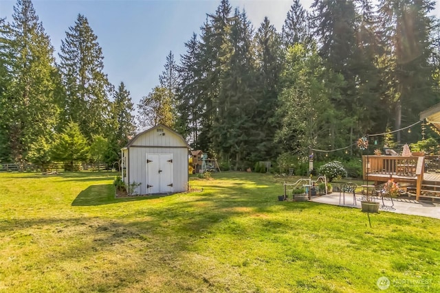 3863 Paradise Bay Rd, Port Ludlow, WA 98365 - view of green lawn with a storage shed, a wooden deck, a patio, and view of scattered trees