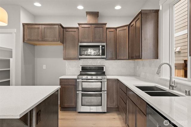 1401 89th Ave SE, Tumwater, WA 98501 - kitchen featuring stainless steel appliances, light wood finished floors, tasteful backsplash, recessed lighting, and light stone countertops