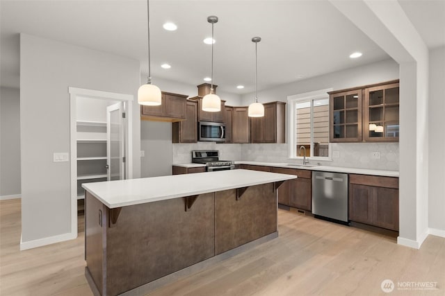 1401 89th Ave SE, Tumwater, WA 98501 - kitchen with stainless steel appliances, decorative backsplash, a kitchen island, light wood-type flooring, and recessed lighting