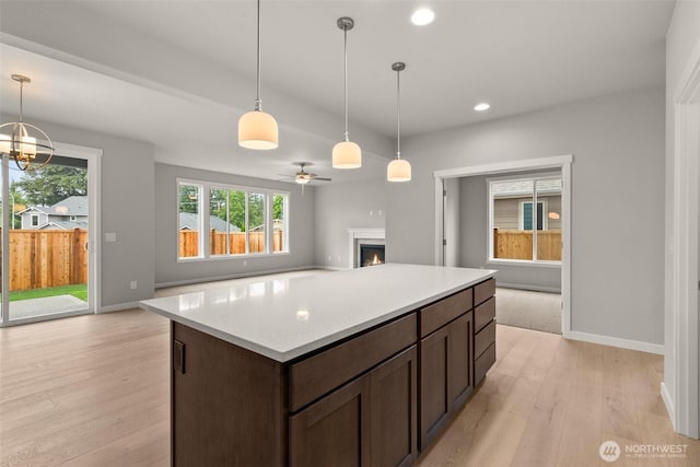 1401 89th Ave SE, Tumwater, WA 98501 - kitchen featuring a lit fireplace, light wood-style floors, light countertops, recessed lighting, and ceiling fan