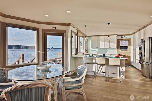 2267 Eastpoint Dr, Langley, WA 98260 - dining space with crown molding, light wood finished floors, recessed lighting, and a water view