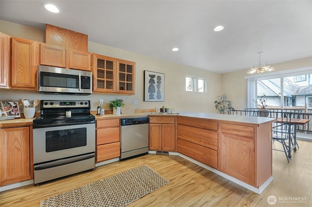 9323 4th Ave W, Everett, WA 98204 - kitchen with stainless steel appliances, a peninsula, light countertops, light wood-style flooring, and recessed lighting