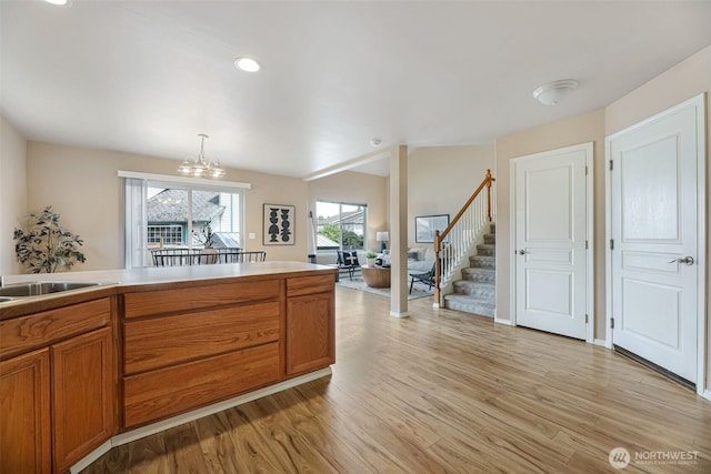 9323 4th Ave W, Everett, WA 98204 - kitchen featuring brown cabinetry, light wood-type flooring, a chandelier, pendant lighting, and light countertops