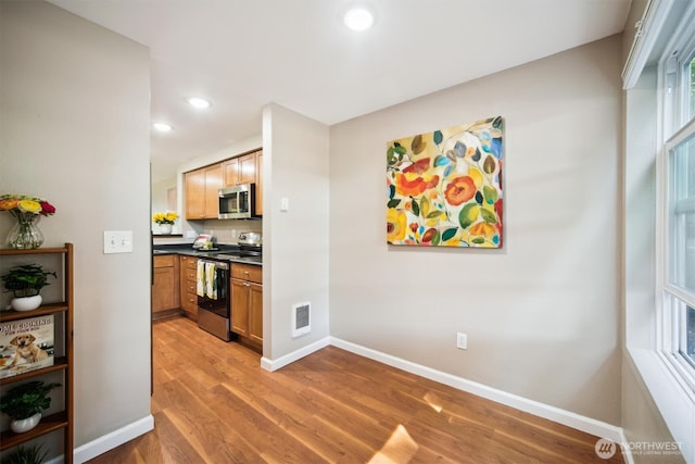 26327 116th Ave SE Unit E102, Kent, WA 98030 - kitchen featuring appliances with stainless steel finishes, light wood-style flooring, recessed lighting, and dark countertops