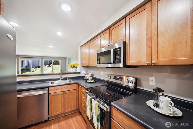 26327 116th Ave SE Unit E102, Kent, WA 98030 - kitchen featuring stainless steel appliances, dark countertops, recessed lighting, light wood-style floors, and brown cabinetry