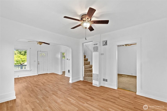 3510 S K St, Tacoma, WA 98418 - unfurnished living room with arched walkways, a ceiling fan, a heating unit, stairs, and light wood finished floors