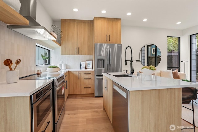 1120 NW 61st St Unit B, Seattle, WA 98107 - kitchen with stainless steel appliances, wall chimney range hood, a breakfast bar area, modern cabinets, and recessed lighting