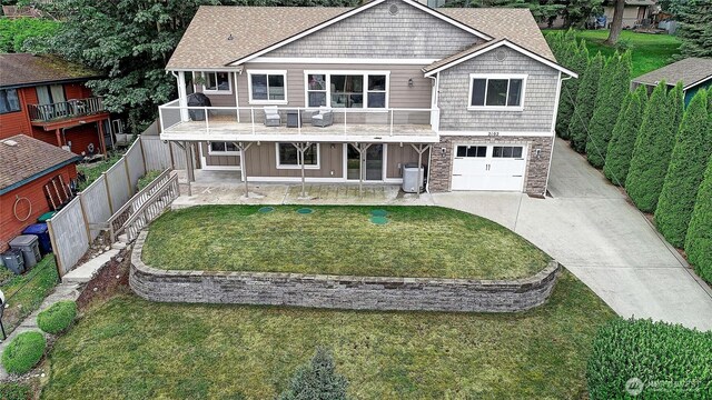 2102 256th St NW, Stanwood, WA 98292 - view of front of property with a garage, driveway, a balcony, a patio, and roof with shingles