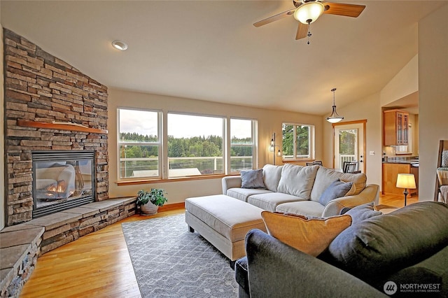 2102 256th St NW, Stanwood, WA 98292 - living room featuring lofted ceiling, ceiling fan, wood finished floors, and a stone fireplace