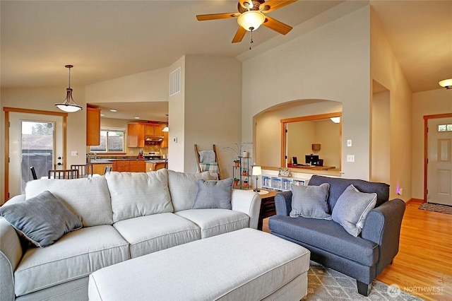 2102 256th St NW, Stanwood, WA 98292 - living room with arched walkways, lofted ceiling, ceiling fan, and light wood-style floors
