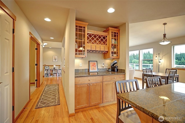 2102 256th St NW, Stanwood, WA 98292 - kitchen with light wood-style floors, glass insert cabinets, recessed lighting, and decorative light fixtures