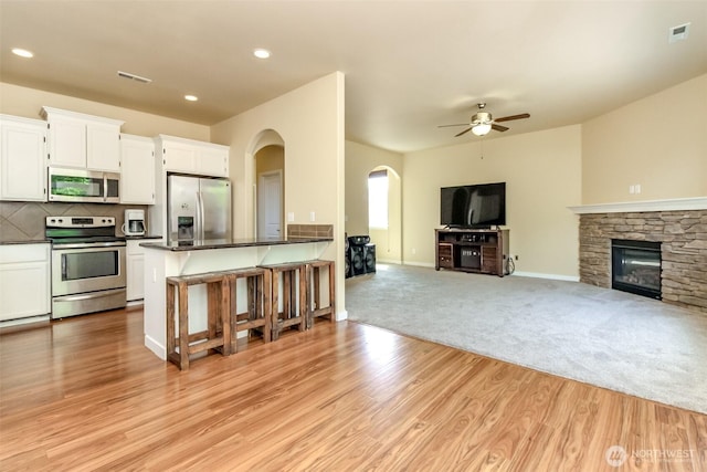 1605 Riddell Ave NE, Orting, WA 98360 - kitchen with stainless steel appliances, dark countertops, a ceiling fan, open floor plan, and arched walkways