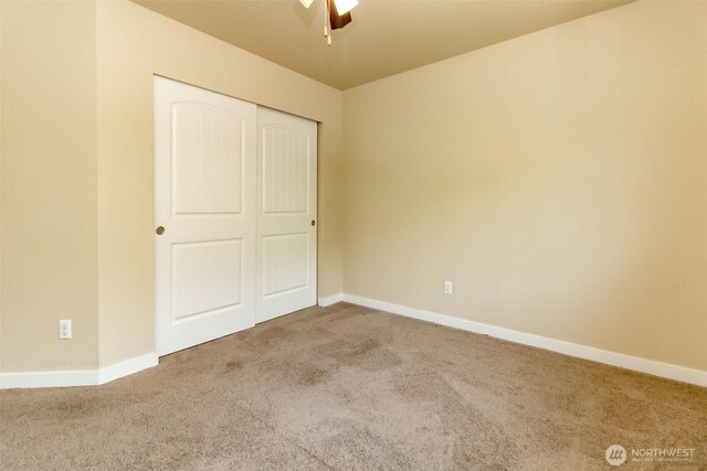 1605 Riddell Ave NE, Orting, WA 98360 - unfurnished bedroom featuring carpet floors, a closet, and a ceiling fan