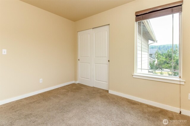 1605 Riddell Ave NE, Orting, WA 98360 - unfurnished bedroom featuring carpet and a closet