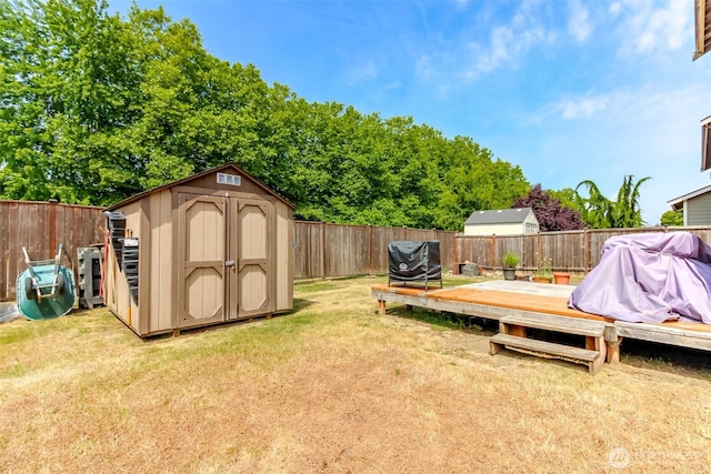 1605 Riddell Ave NE, Orting, WA 98360 - fenced backyard featuring a storage unit and a wooden deck