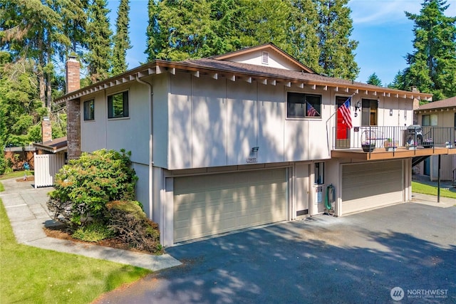 2822 Garden Ct Unit B, Steilacoom, WA 98388 - view of front facade with a garage, asphalt driveway, a chimney, and a balcony