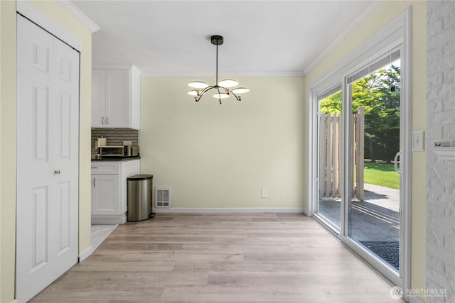 2822 Garden Ct Unit B, Steilacoom, WA 98388 - unfurnished dining area with crown molding, a chandelier, and light wood-style flooring