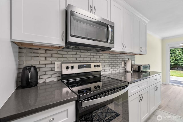 2822 Garden Ct Unit B, Steilacoom, WA 98388 - kitchen with stainless steel appliances, ornamental molding, backsplash, and white cabinets