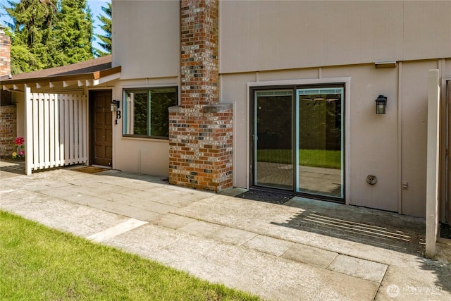 2822 Garden Ct Unit B, Steilacoom, WA 98388 - view of exterior entry featuring a patio area and a chimney