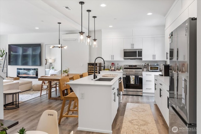 21511 50th Ave W Unit E, Mountlake Terrace, WA 98043 - kitchen with stainless steel appliances, a wall unit AC, open floor plan, pendant lighting, and light countertops