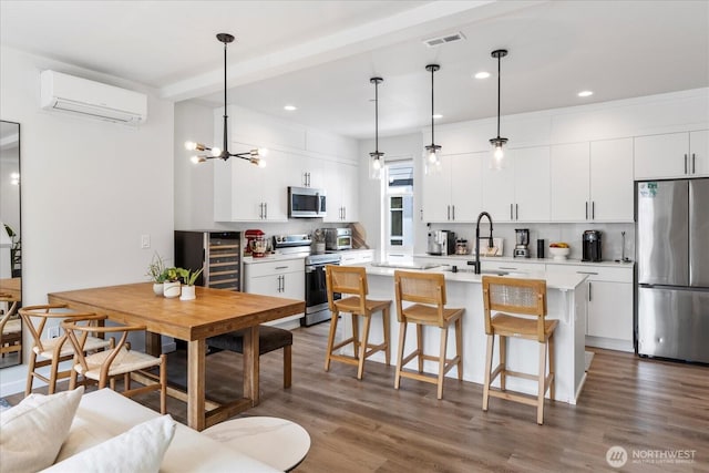 21511 50th Ave W Unit E, Mountlake Terrace, WA 98043 - kitchen featuring stainless steel appliances, an AC wall unit, wine cooler, a kitchen breakfast bar, and light countertops