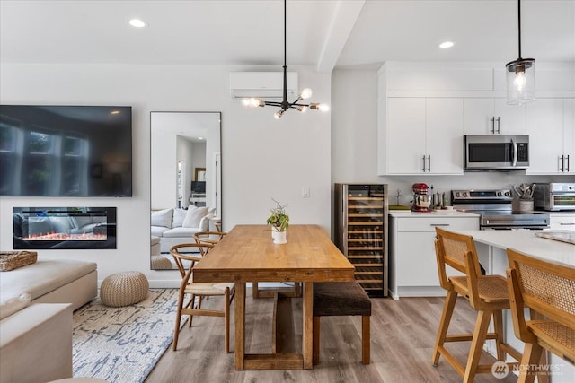21511 50th Ave W Unit E, Mountlake Terrace, WA 98043 - dining space featuring beverage cooler, a wall mounted AC, light wood-type flooring, a chandelier, and a glass covered fireplace