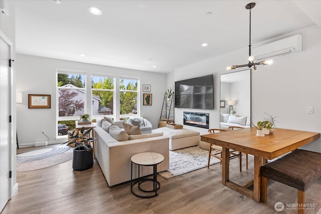 21511 50th Ave W Unit E, Mountlake Terrace, WA 98043 - living area with a wall mounted air conditioner, wood finished floors, a glass covered fireplace, recessed lighting, and a chandelier
