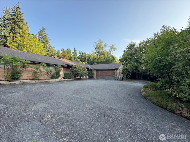 8855 Points Dr NE, Clyde Hill, WA 98004 - view of side of property with a garage, driveway, and a chimney
