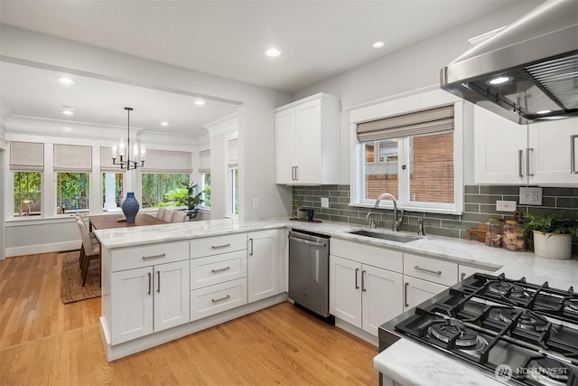2836 32nd Ave S, Seattle, WA 98144 - kitchen with stainless steel dishwasher, wall chimney range hood, a peninsula, white cabinets, and plenty of natural light