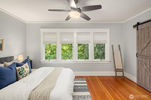 2836 32nd Ave S, Seattle, WA 98144 - bedroom featuring a barn door, crown molding, wood finished floors, and a ceiling fan