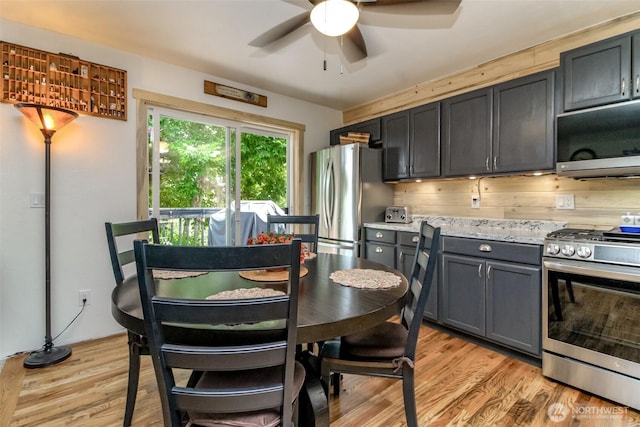 15205 197th St E, Orting, WA 98360 - kitchen with appliances with stainless steel finishes, a ceiling fan, light wood finished floors, gray cabinetry, and light stone counters