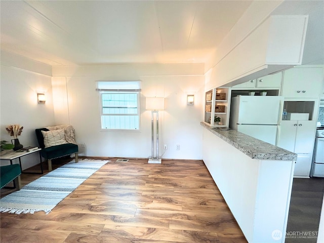 105 E Cox Ave Unit 13, Arlington, WA 98223 - kitchen featuring freestanding refrigerator, dark wood-style floors, range, light stone countertops, and a peninsula