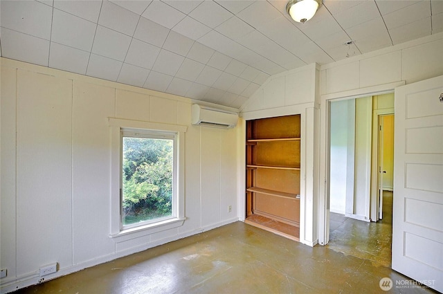 522 Chapman Rd, Camano Island, WA 98282 - unfurnished bedroom featuring a wall mounted air conditioner, concrete flooring, a decorative wall, and lofted ceiling