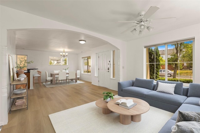 331 Index Ave SE, Renton, WA 98056 - living room featuring light wood-type flooring, arched walkways, ceiling fan, and a chandelier