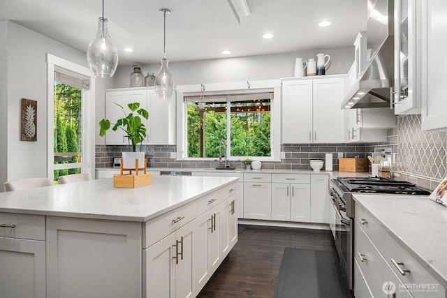 2283 244th Ave SE, Sammamish, WA 98075 - kitchen with high end stove, wall chimney exhaust hood, white cabinets, decorative backsplash, and a center island