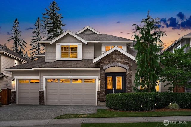 2283 244th Ave SE, Sammamish, WA 98075 - view of front of property with stone siding, driveway, an attached garage, and roof with shingles