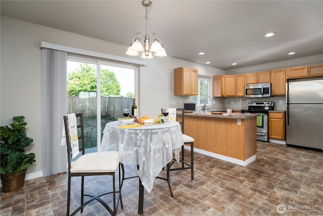 9960 Locust Ct SE, Yelm, WA 98597 - kitchen with appliances with stainless steel finishes, a chandelier, recessed lighting, decorative light fixtures, and a peninsula