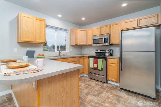 9960 Locust Ct SE, Yelm, WA 98597 - kitchen with appliances with stainless steel finishes, light brown cabinetry, a peninsula, light countertops, and recessed lighting