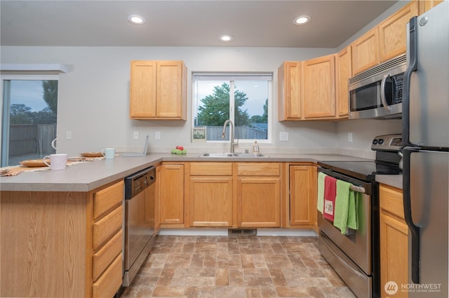 9960 Locust Ct SE, Yelm, WA 98597 - kitchen with appliances with stainless steel finishes, a peninsula, light brown cabinetry, light countertops, and recessed lighting