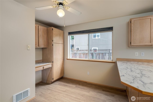21312 87th Ave NE Unit 1 & 2, Arlington, WA 98223 - kitchen with light brown cabinets, built in desk, light wood-style floors, light countertops, and a ceiling fan