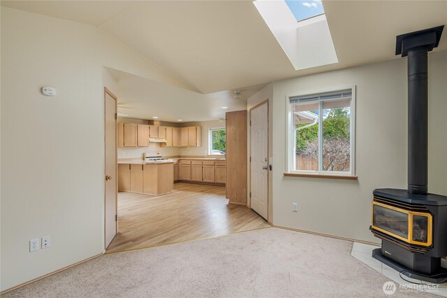 21312 87th Ave NE Unit 1 & 2, Arlington, WA 98223 - kitchen featuring light brown cabinetry, a wood stove, under cabinet range hood, lofted ceiling, and light countertops